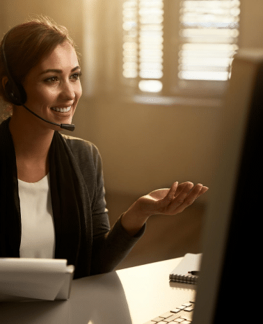 Happy customer service representative using computer while communicating with clients online